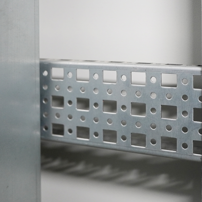 Close-up of perforated steel channel with square holes in an industrial metal frame.
