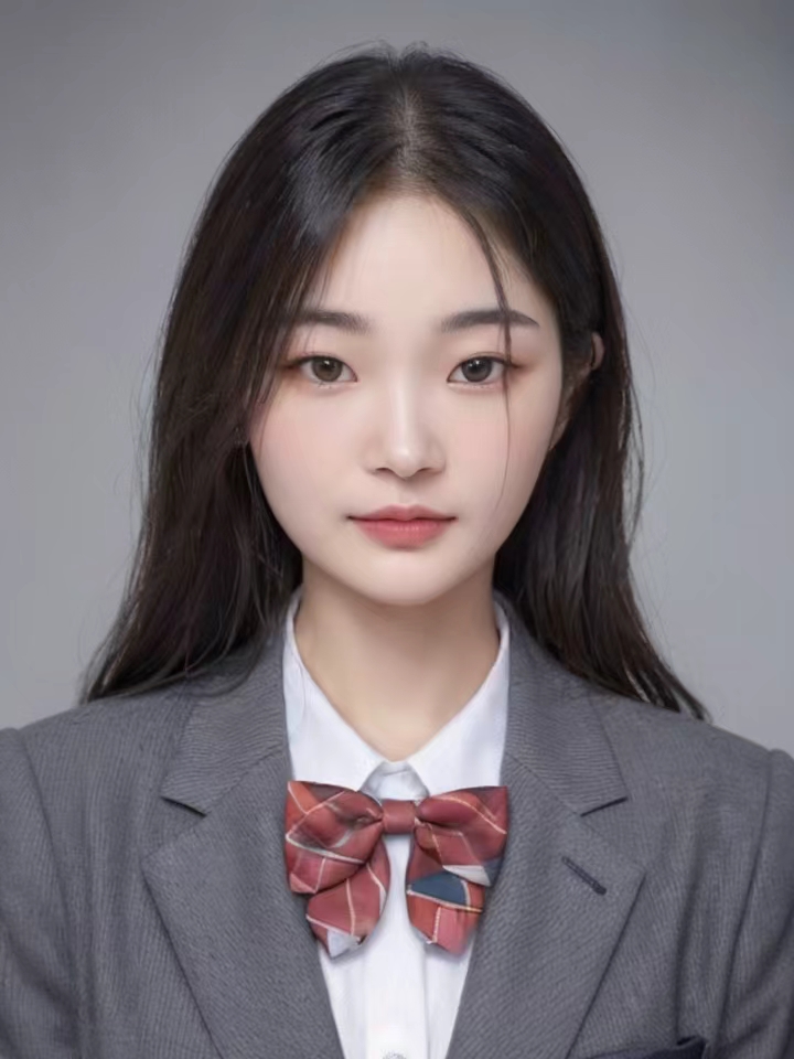 Young woman in gray school uniform blazer with red plaid bow tie on gray backdrop.