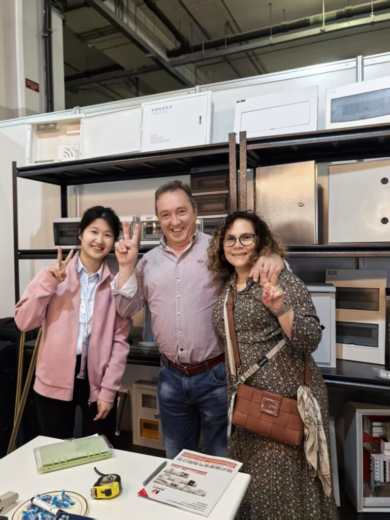 Three Colleagues Posing at Workshop Table with Peace Signs